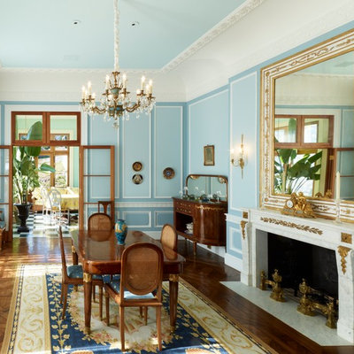 Large elegant medium tone wood floor and brown floor enclosed dining room photo in Boston with blue walls, a stone fireplace and a standard fireplace