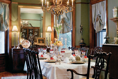 Elegant dark wood floor dining room photo in St Louis with green walls