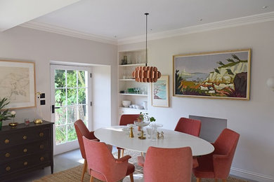 Foto di una sala da pranzo aperta verso la cucina minimalista di medie dimensioni con pareti bianche, pavimento in cemento, stufa a legna, cornice del camino in pietra e pavimento grigio