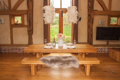 Example of a large mountain style medium tone wood floor great room design in Sussex with beige walls and no fireplace