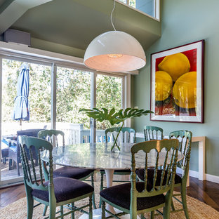Immagine di una sala da pranzo boho chic con pareti verdi, parquet scuro e pavimento beige