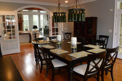 Enclosed dining room - contemporary medium tone wood floor enclosed dining room idea in Boston with gray walls and no fireplace