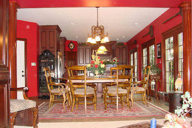 Foto de comedor de cocina clásico de tamaño medio sin chimenea con paredes rojas y suelo de madera oscura