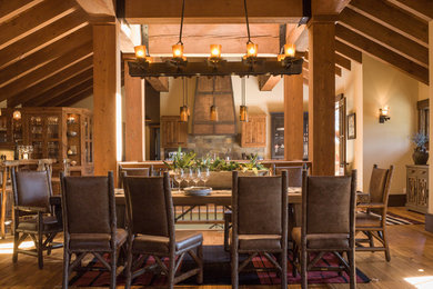 Immagine di una grande sala da pranzo aperta verso il soggiorno stile rurale con pareti beige, pavimento in legno massello medio, nessun camino e pavimento marrone