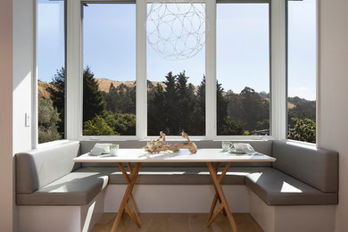 Example of a trendy light wood floor and brown floor dining room design in Sacramento with white walls and no fireplace