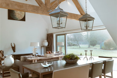 Inspiration for a large rural open plan dining room in Oxfordshire with white walls, limestone flooring and feature lighting.