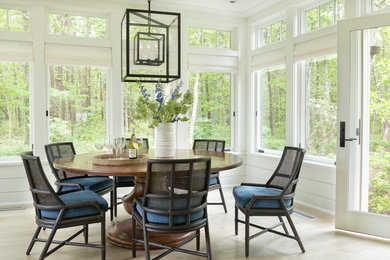 Example of a beach style light wood floor and beige floor dining room design in Boston with white walls and no fireplace