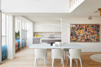 This is an example of a large contemporary dining room in San Francisco with white walls and light hardwood flooring.