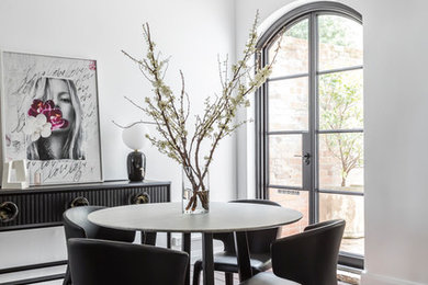 Cette photo montre une salle à manger ouverte sur le salon moderne de taille moyenne avec un mur blanc et parquet foncé.