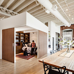 Immagine di una sala da pranzo industriale con parquet chiaro