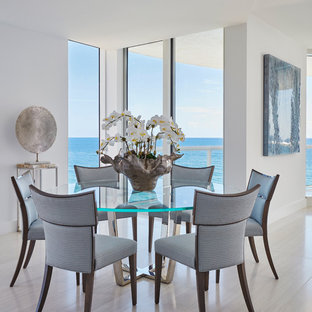 Diseño de comedor costero, abierto, sin chimenea, con paredes blancas, suelo gris y suelo de baldosas de porcelana