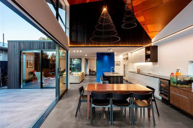 Aménagement d'une salle à manger ouverte sur la cuisine contemporaine avec un sol en carrelage de céramique et un sol gris.