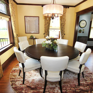 Imagen de comedor de estilo americano, grande, cerrado, sin chimenea, con suelo de madera en tonos medios y paredes amarillas