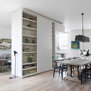 Imagen de comedor contemporáneo, abierto, con paredes blancas y suelo de madera clara