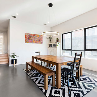 Inspiration for a large scandinavian dining room in Melbourne with white walls, grey floor and no fireplace.