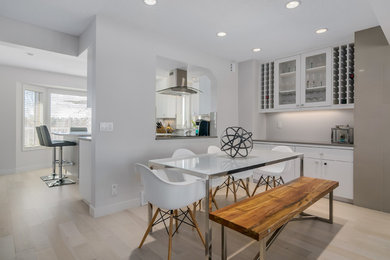 Mittelgroße Moderne Wohnküche ohne Kamin mit weißer Wandfarbe und hellem Holzboden in Calgary