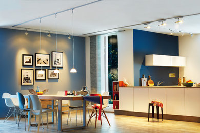 ハノーファーにある広い北欧スタイルのおしゃれなダイニングキッチン (青い壁、無垢フローリング、暖炉なし、茶色い床) の写真