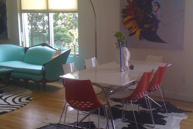 Cette photo montre une salle à manger ouverte sur le salon tendance de taille moyenne avec un mur blanc et parquet en bambou.