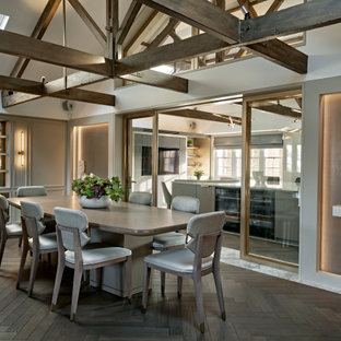 Idée de décoration pour une salle à manger tradition fermée avec un mur gris, un sol en bois foncé, aucune cheminée, un plafond en poutres apparentes, un plafond voûté et du lambris.