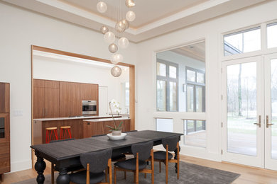 ニューヨークにある高級な広いコンテンポラリースタイルのおしゃれなダイニングキッチン (白い壁、淡色無垢フローリング、両方向型暖炉、漆喰の暖炉まわり、茶色い床) の写真