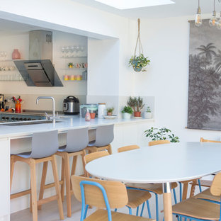 Diseño de comedor de cocina exótico, sin chimenea, con paredes blancas y suelo gris