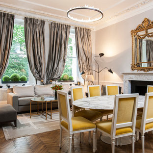 Idee per una sala da pranzo aperta verso il soggiorno classica con pareti grigie, camino classico, cornice del camino in pietra e parquet scuro