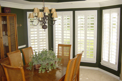 Medium sized classic enclosed dining room in Houston with green walls, carpet, no fireplace and beige floors.