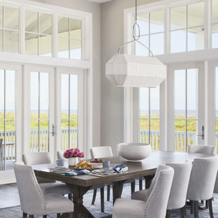 Esempio di una grande sala da pranzo aperta verso il soggiorno stile marino con pareti grigie, pavimento in vinile, pavimento marrone e travi a vista