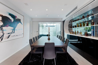 Inspiration pour une salle à manger ouverte sur la cuisine design de taille moyenne avec un mur blanc et sol en béton ciré.