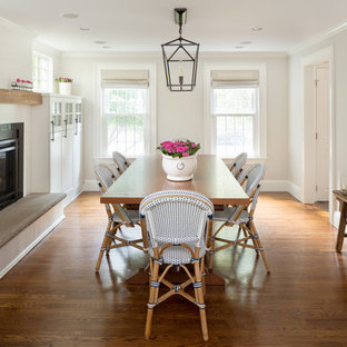 Mittelgroßes Klassisches Esszimmer mit grauer Wandfarbe, braunem Holzboden, Kamin, Kaminumrandung aus Metall und braunem Boden in Boston
