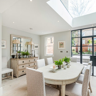 Classic dining room in London with white walls, light hardwood flooring, no fireplace and beige floors.