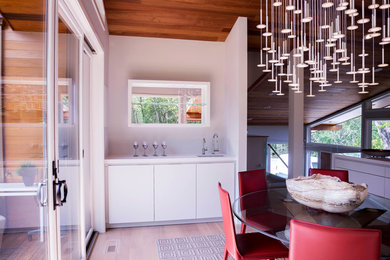 This is an example of a large contemporary enclosed dining room in San Francisco with grey walls and light hardwood flooring.