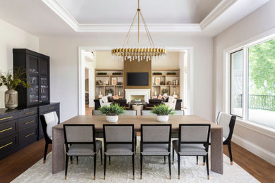 Ispirazione per una sala da pranzo aperta verso la cucina classica di medie dimensioni con pareti bianche, pavimento in legno massello medio e pavimento beige