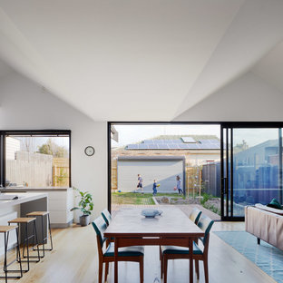 Design ideas for a large contemporary open plan dining in Melbourne with white walls, light hardwood floors, no fireplace and beige floor.