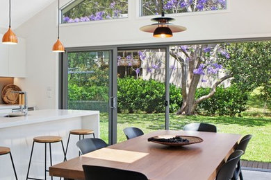 Стильный дизайн: кухня-столовая среднего размера в современном стиле с белыми стенами, бетонным полом и серым полом - последний тренд