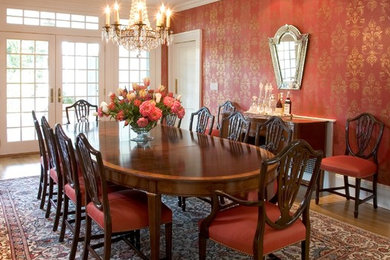 Idées déco pour une salle à manger classique avec un mur rouge et un sol en bois brun.
