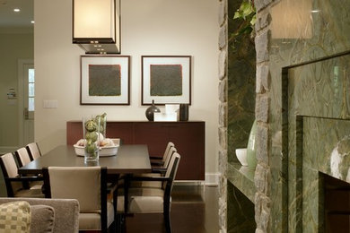 Aménagement d'une salle à manger classique avec un mur blanc, parquet foncé, une cheminée standard, un manteau de cheminée en pierre et un sol marron.