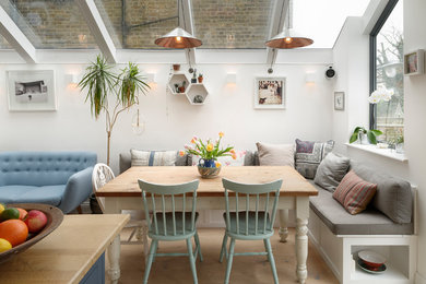 Design ideas for a large traditional kitchen/dining room in London with light hardwood flooring, white walls and beige floors.