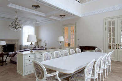 На фото: гостиная-столовая среднего размера в классическом стиле с бежевыми стенами, деревянным полом, стандартным камином, фасадом камина из штукатурки и коричневым полом