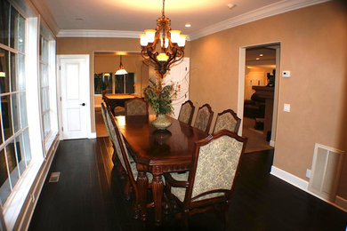Example of a mid-sized classic dark wood floor and brown floor enclosed dining room design in Other with beige walls