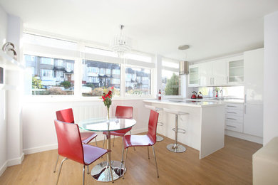 Inspiration for a small modern kitchen/dining room in London with white walls, light hardwood flooring and no fireplace.