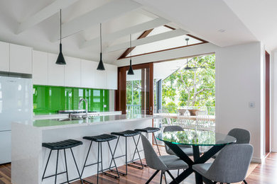 Diseño de comedor moderno abierto con paredes blancas y suelo de madera en tonos medios