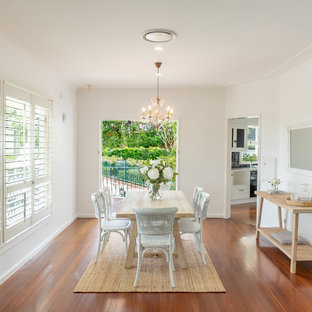Beach style separate dining room in Other with white walls, medium hardwood floors, no fireplace and brown floor.