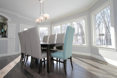 Large trendy light wood floor and gray floor enclosed dining room photo in Cleveland with gray walls
