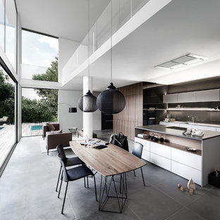 Foto di una grande sala da pranzo aperta verso la cucina design con pareti bianche e pavimento in ardesia