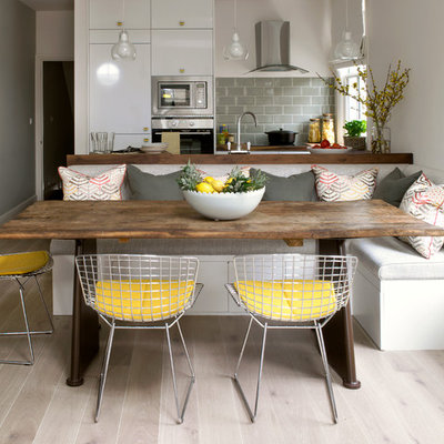 Trendy light wood floor and beige floor kitchen/dining room combo photo in London with white walls