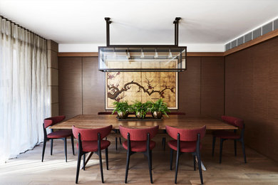 Imagen de comedor contemporáneo grande sin chimenea con paredes marrones, suelo de madera en tonos medios y suelo marrón