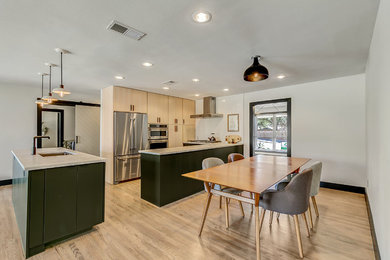Mid-sized minimalist u-shaped light wood floor and gray floor eat-in kitchen photo in Dallas with an undermount sink, flat-panel cabinets, white backsplash, stainless steel appliances, an island, light wood cabinets, quartz countertops, brick backsplash and multicolored countertops