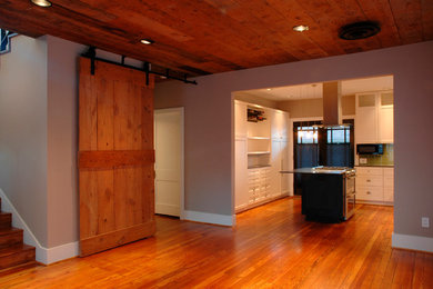 Aménagement d'une salle à manger ouverte sur la cuisine craftsman avec un mur beige et un sol en bois brun.