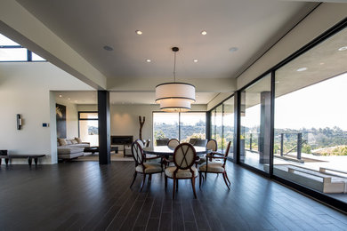 Example of a large trendy dark wood floor and brown floor great room design in San Diego with white walls and no fireplace